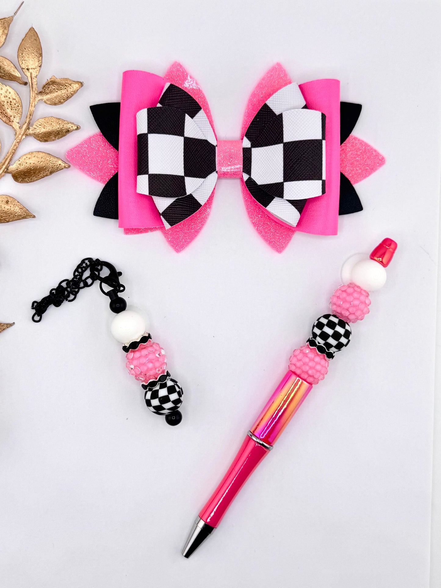 Hot pink faux leather bow set with black and white checkered center and matching beaded pen and keychain charm with pink and checker beads.