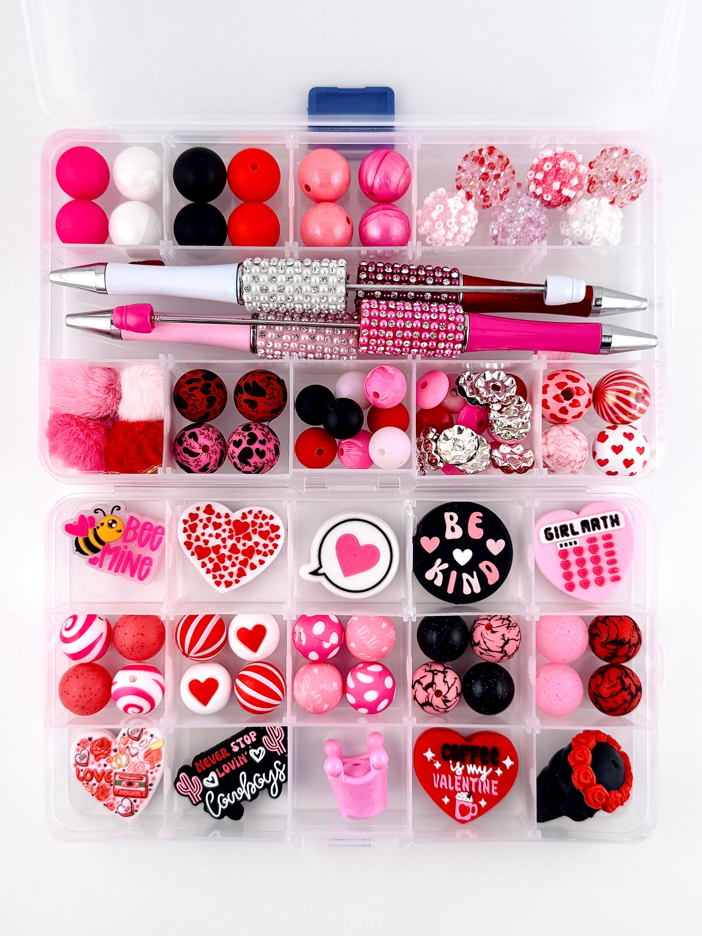 “92 piece Valentine’s Day bead starter kit featuring pink, red, white, and black silicone beads, heart-themed acrylic focals, rhinestone pens, pom poms, and Valentine charms arranged in a clear organizer box”