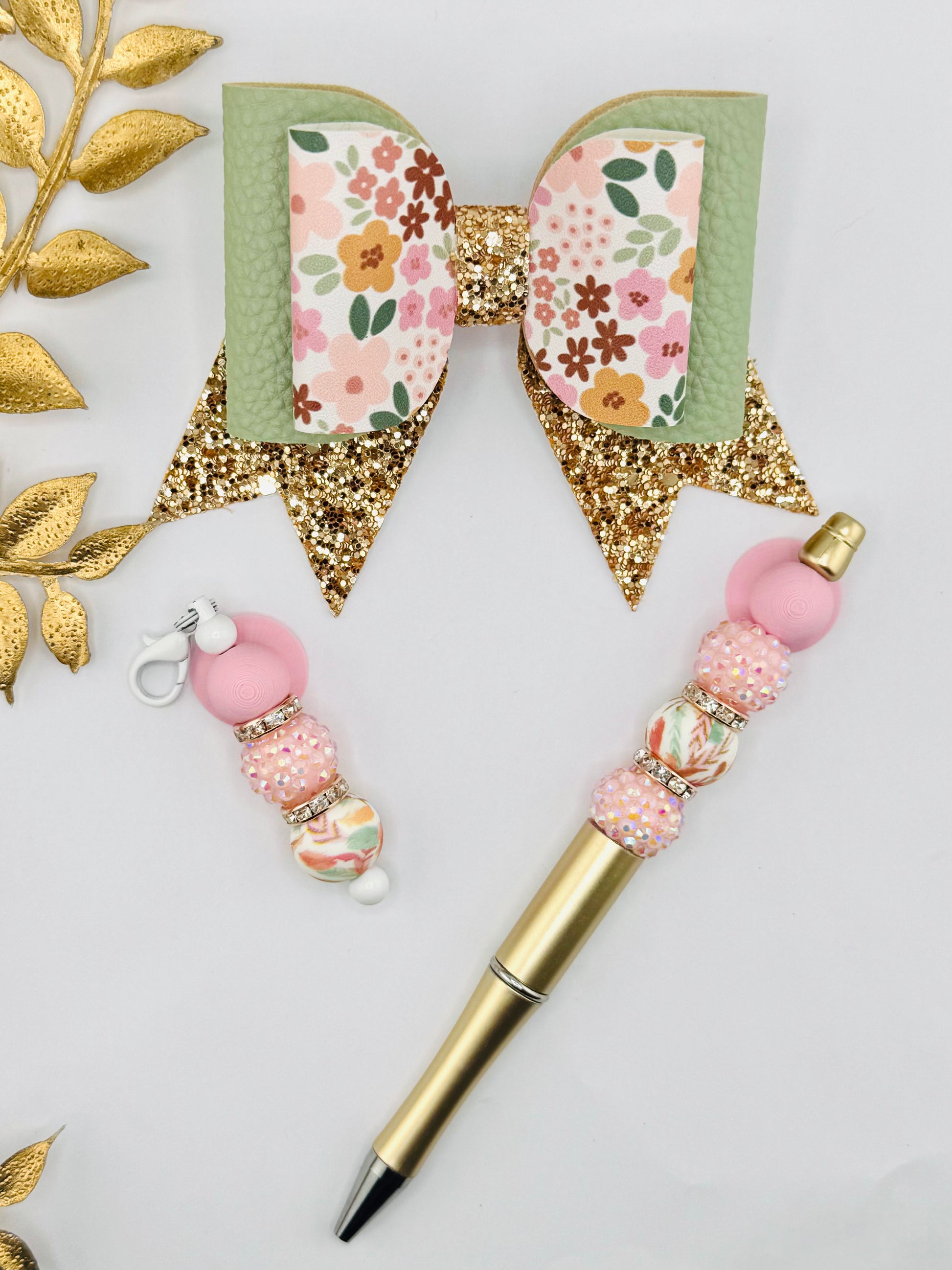 Decorative pen with floral accents and gold elements on a light gray background