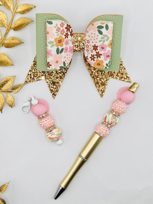 Decorative pen with floral accents and gold elements on a light gray background
