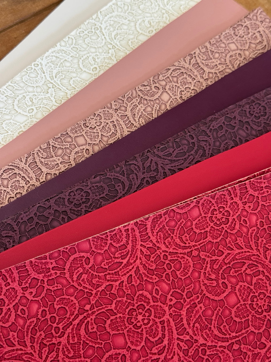 Faux leather lace sheets paired with matching solids in ivory, dusty rose, plum and red