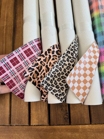 Faux leather print rolls with Christmas plaid, large and small leopard, chestnut checker, neon plaid and neon stars