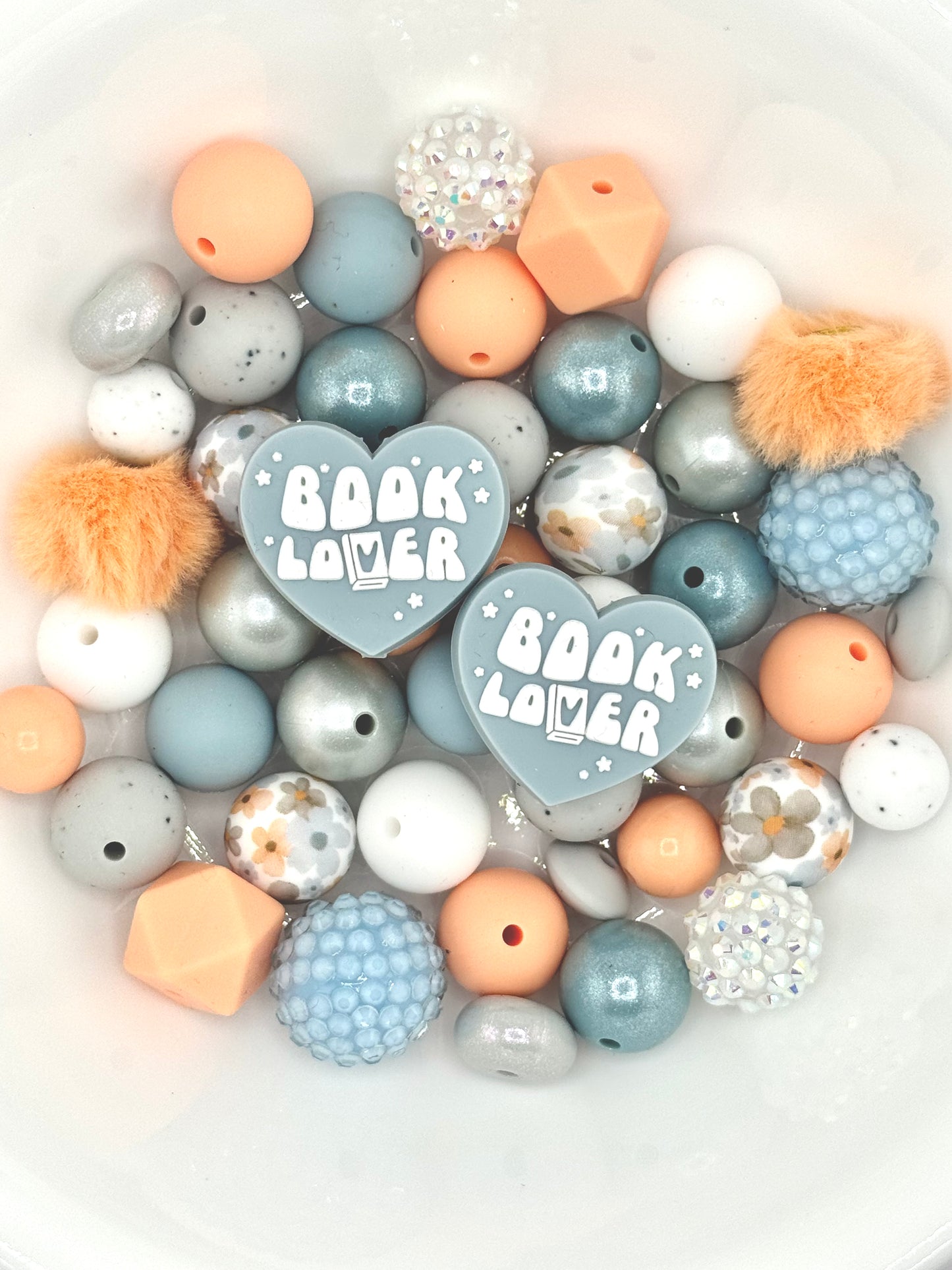 Book Lover themed silicone bead mix featuring peach, dusty blue, and soft gray beads with heart book lover focal beads, floral accents, and textured silicone beads for DIY wristlets, lanyards, and keychains.