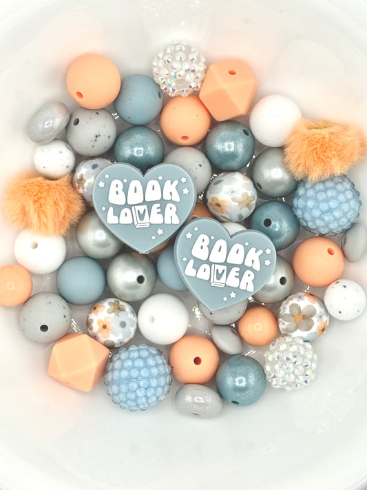 Book Lover themed silicone bead mix featuring peach, dusty blue, and soft gray beads with heart book lover focal beads, floral accents, and textured silicone beads for DIY wristlets, lanyards, and keychains.