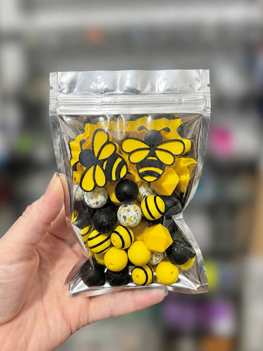 Black and yellow bumblebee curated silicone bead mix with two 3D-printed bee focals in a clear pouch