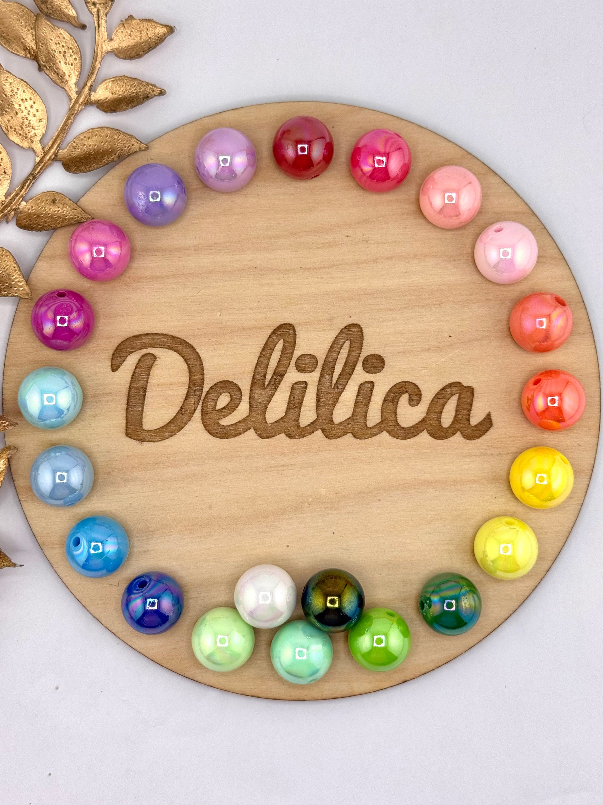 Opal 16mm acrylic beads in assorted colors arranged in a circle on a Delilica wooden display board